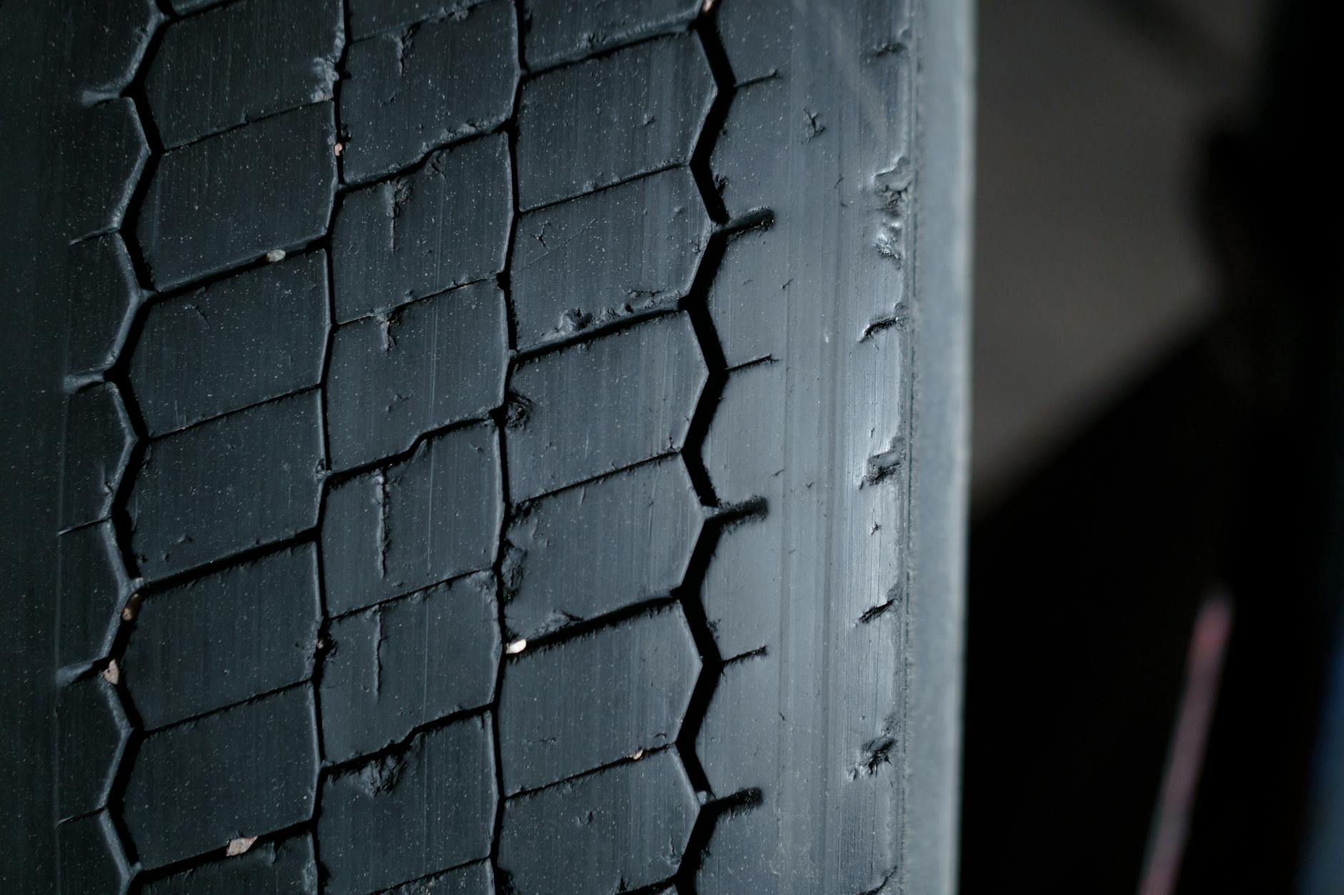 a close up photography of a tire with pebbles in treads